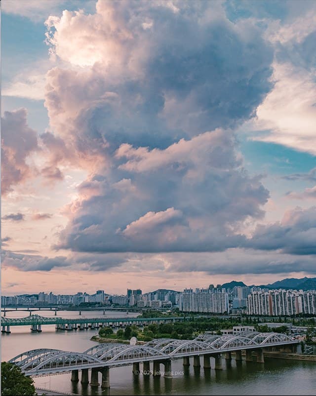 Towering clouds above the Han River rail bridge at Yongyangbongjeojeong Park